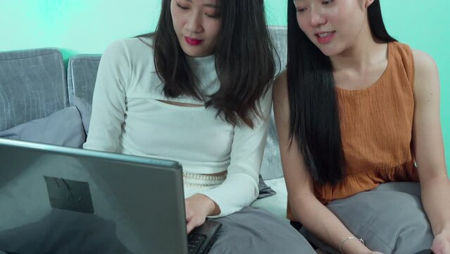 Asian toursit girls seraching information planning for vacation trip, young backpacker using laptop in hostel, woman texting message on technology notebook digital nomad working or shopping online
