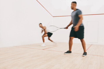 Fototapeta na wymiar The more you practice the better you become. two young men playing a game of squash.