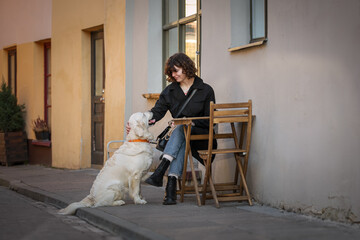 Cute funny girl portrait with her golden dog on street 