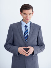 Conniving businessman. A conniving young businessman with his fingers together while isolated on white.