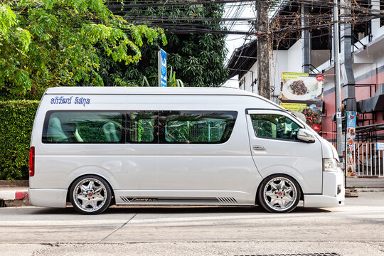White Toyota Commuter Hiace with big alloy wheels on the road in the city with traffic.