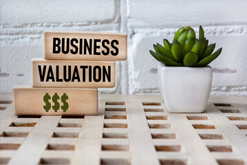 Business valuation. Wooden blocks showing the words. Vintage background with a flower. Basic concepts of finance. Business theme. financial terms.