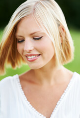 Fototapeta premium Sweet and naturally lovely. Gorgeous young woman looking downwards outdoors.