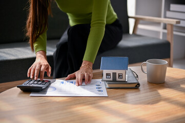 Close-up image of a woman calculating house loan, planning banking loan