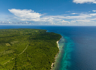 Tropical beach with crystal clear water in the tropics. Turquoise lagoon surface on atoll and coral reef. Siquijor, Philippines.