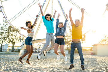 Group of young people jumping on the sand, friends having fun in a beach party, freedom and joyful...