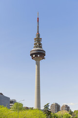 Telecommunications tower of Madrid along with some nearby buildings at the base and a bit of blue sky