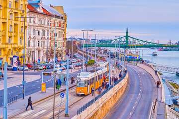 Jane Haining rkp (quay) in the evening rush hour with yellow  tram on the stop, Budapest, Hungary