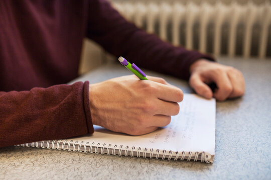 Man studying and writing in notebook