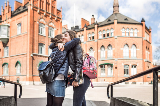 Female friends hugging in school courtyard