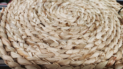 Round braided natural straw table mat texture as a background. Full frame of tightly woven straw pattern. Ppace, copy space for text, for background