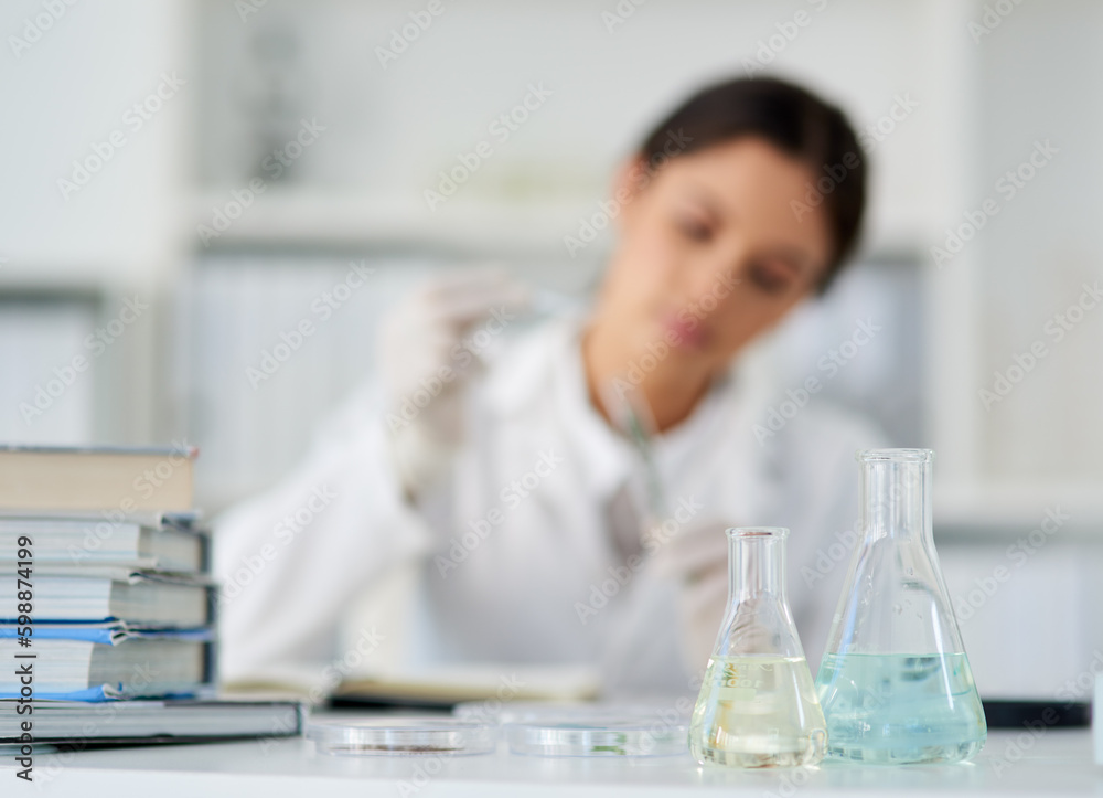 Aufkleber Lets get experimenting for the day. beakers in a lab with a young scientist working in the background.