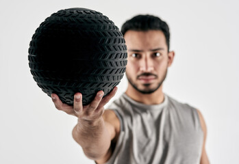No excuses. Just do the work. Studio portrait of a muscular young man holding an exercise ball...