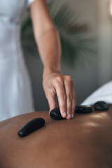These stones have healing powers. Closeups shot of an unrecognisable woman getting a hot stone massage at a spa.