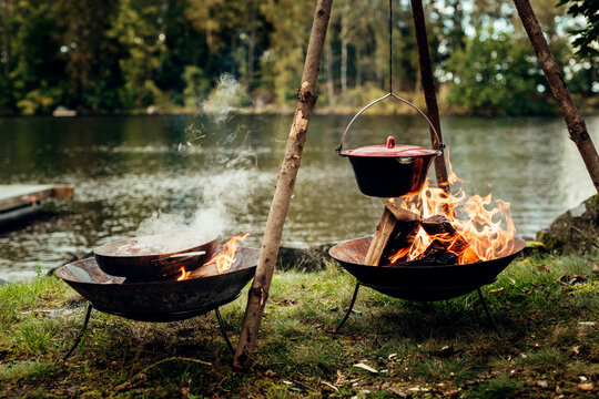 Food cooking in pot and pan over campfires