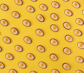 Chocolate eggs pattern on yellow background. Food pattern. View from above. Food fashion minimalistic concept. Flat lay.