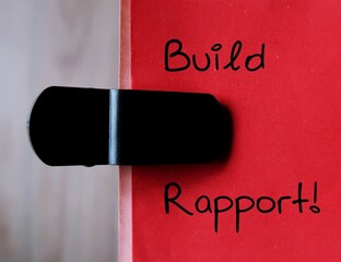 Office note paper with handwriting BUILD RAPPORT, to remind self to building relationships with others in which both parties feel supported and understood to accomplish career goals