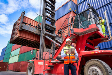 Foreman and the tablet working with team in logistic container box siite.