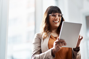 Everyone loves seeing progress, especially in business. an attractive young businesswoman using a digital tablet in her office.