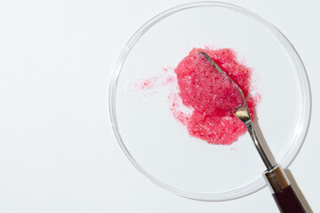 Natural Scrub with Heating Effect in Laboratory Petri Dish with metal Spatula for testing Sample on white background