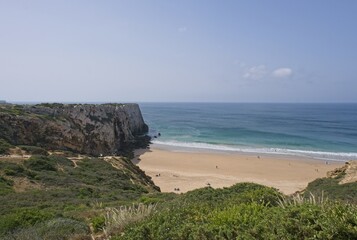 Fototapeta na wymiar Wonderful landscapes in Portugal. Scenic coastline in Sagres. Praia do Beliche view from the cliff. Wavy sea. Rocky skerries. Sunny spring day. Selective focus