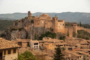 Fototapeta premium Panoramic and aerial view of the impressive and touristic medieval style village of Alquezar, in Aragon, with small brick houses and a Romanesque style church at the top.