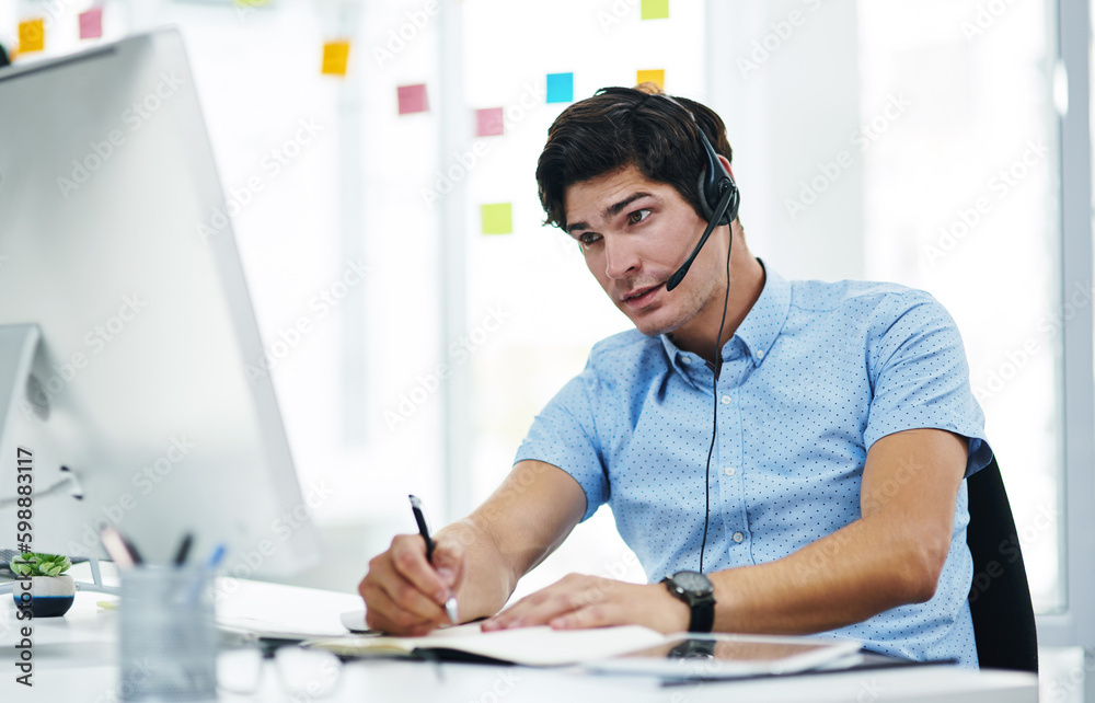 Aufkleber Can you repeat that for me please. a young businessman using a headset while working on a computer in an office.