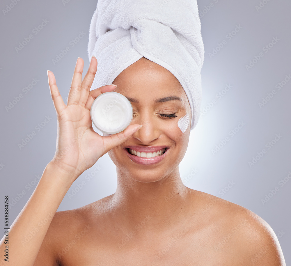 Poster Get yourself one of these. an attractive young woman feeling playful while posing with a container of moisturiser in the studio.