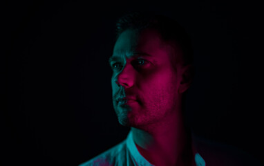 Portrait of a handsome unshaven middle-aged man. In neon light.