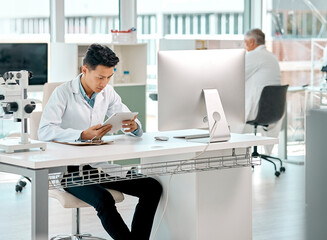 Using an app to guide him through his study. a young scientist using a digital tablet in a lab.