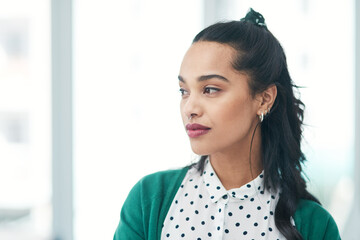 Determination will take you in the direction you deserve. a young businesswoman looking thoughtful in a modern office.