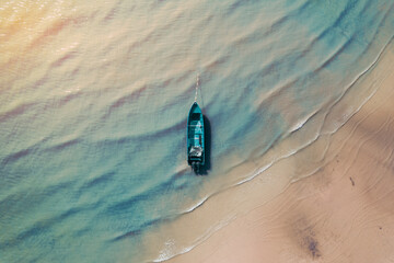 Top view of fishing boat at low tide in the afternoon