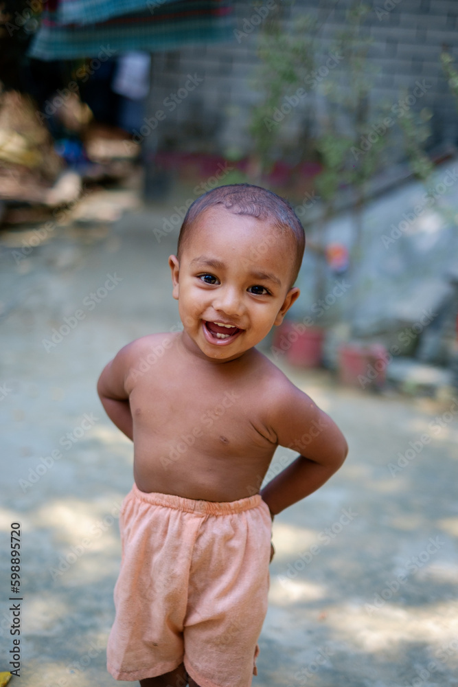 Wall mural south asian little cute adorable baby boy having fun and showing happy gestures standing outside hom