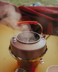 Boiling water with a small kettle in the tent while camping