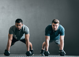 Were ready, are you. Full length portrait of two handsome young male athletes working out with...