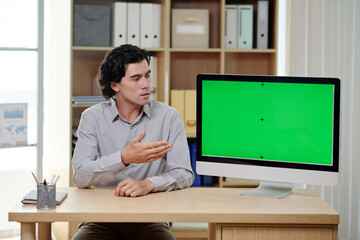 Serious businessman showing presentation on computer screen in meeting with investors