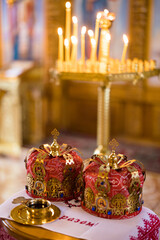 Fototapeta na wymiar Closeup view to wedding crowns on embroidered towel during a wedding ceremony in Orthodox Ukrainian church.