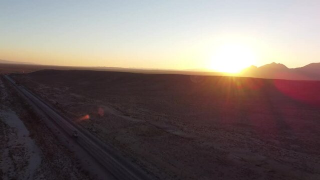 Aerial drone top down shot over vehicle movement on RCD road in Baluchistan with sun rising in the background