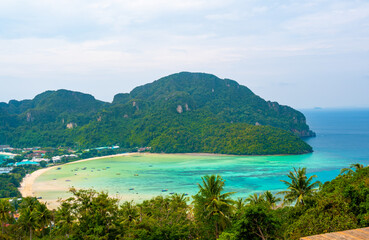 Aerial view of Ko Phi Phi islands, Thailand. Lookout from the viewpoint to tropical island, beach and ocean with long tail boats. Exotic nature, summer weather.