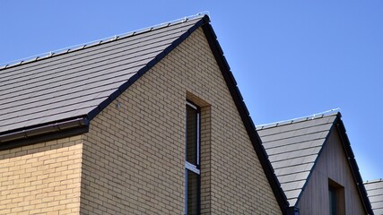Terraced family homes in newly developed housing estate. The real estate market in the suburbs. New single family houses in a new development area. Residential homes with modern facade. 