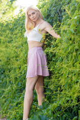 Naklejka na ściany i meble Happy young woman enjoying summer on green grass