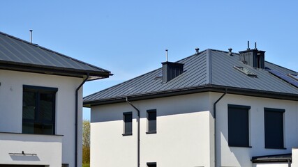 Terraced family homes in newly developed housing estate. The real estate market in the suburbs. New single family houses in a new development area. Residential homes with modern facade. 