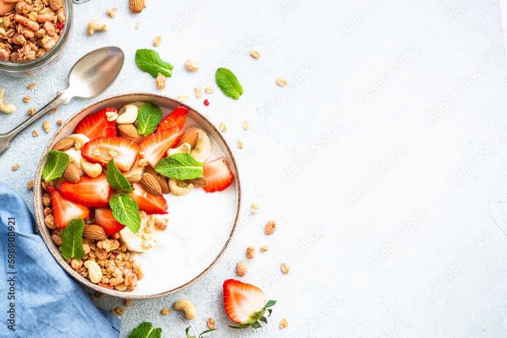 Canvas Prints Healthy breakfast, Yogurt with granola, nuts and strawberries on white background. Top view with copy space.