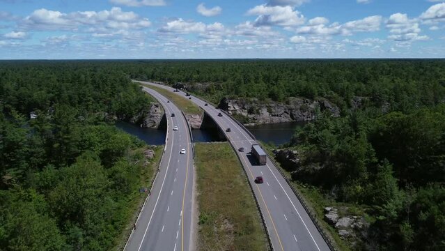 Low traffic flyover of curved highway bridge through rock and trees near Gravenhurst Ontario