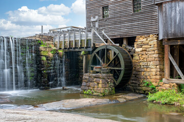 Yates Mill in North Carolina closeup of waterwheel, pond, and building.