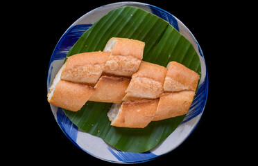 Sliced Vietnamese traditional Banh Mi baguette on black background