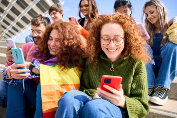 Group young friends watching mobile phone and celebrating gay pride festival day together. Cheerful...