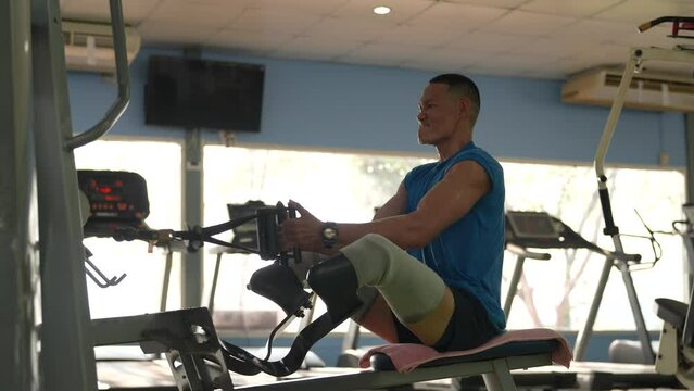 Man with prosthetic legs using rowing machine