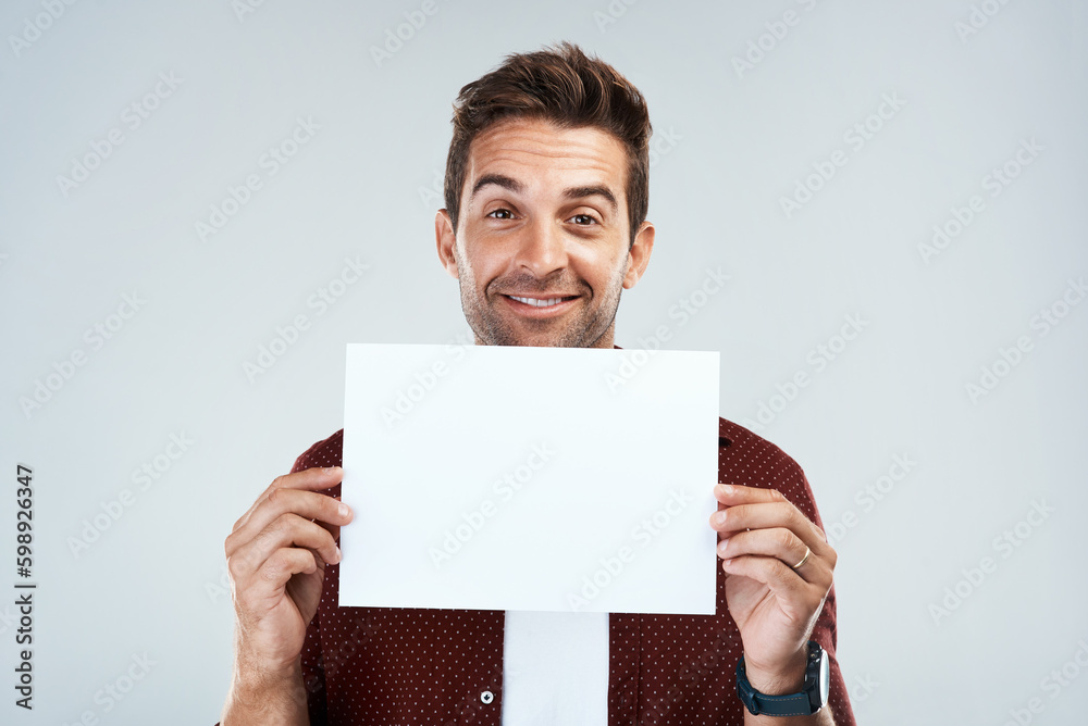 Poster i just made this for you. portrait of a cheerful young man holding and displaying a poster while sta