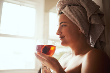 No coffee, no problem. a young woman having tea while going through her morning beauty routine at home.